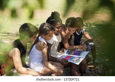 Young people and education, two little girls and boys reading book in city park - Powered by Shutterstock