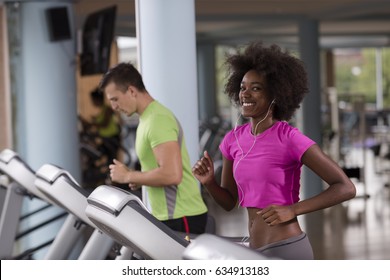 Young People Exercisinng A Cardio On Treadmill Running Machine In Modern Gym