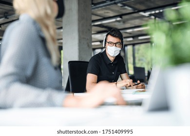 Young People With Face Masks Back At Work In Office After Lockdown, Talking.