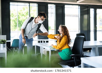 Young People With Face Masks Back At Work In Office After Lockdown, Greeting.