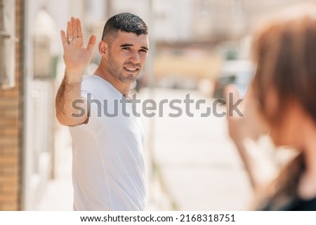 young people greeting or saying goodbye in the city street