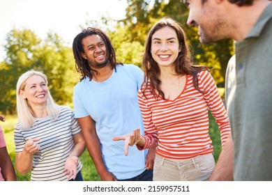 Young people group as a clique of friends in the park in summer having small talk - Shutterstock ID 2159957511