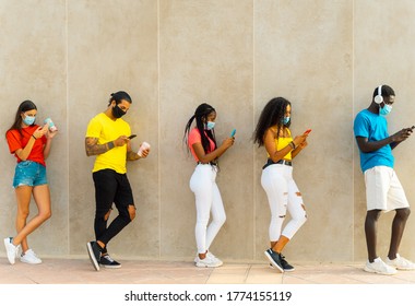 Young people group with face mask waiting to get in the supermarket. Coronavirus and spread virus prevention concept. Image - Powered by Shutterstock