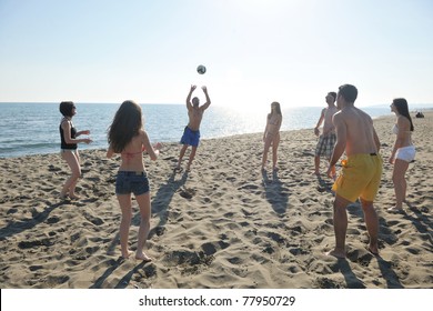 Young People Group Have Fun And Play Beach Volleyball At Sunny Summer Day