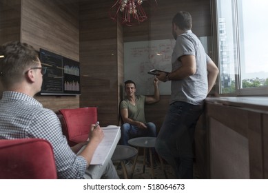 Jugendgruppen in kleinen Privatbüros haben Teamtreffen und Brainstorming während der Arbeit an Laptop- und Tablet-Computern