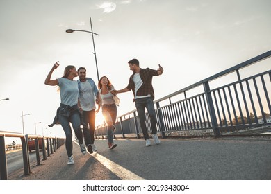 Young people hangout at the city street.They walking over the bridge and joying in autumn sunset.	 - Powered by Shutterstock