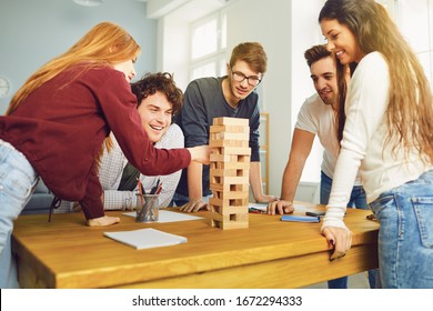 Young People Have Fun Playing Board Games At A Table In The Room.