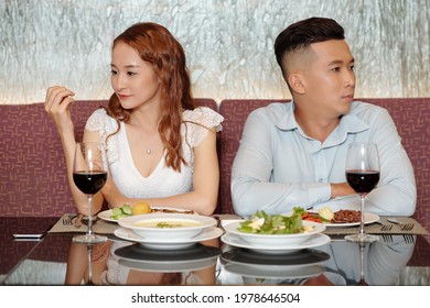 Young People Having Bad First Date, They Are Sitting At Restaurant Table, Not Talking And Looking In Different Directions