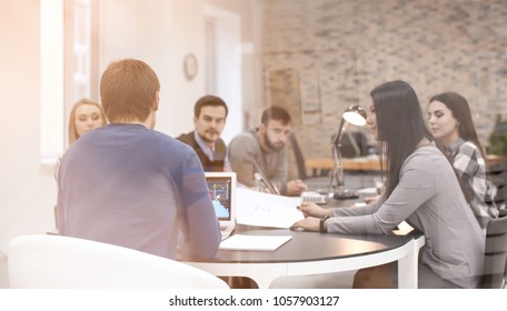 Young People Having Business Meeting In Conference Room, View Through Glass