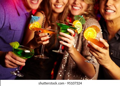 Young people having fun at a birthday party with cocktails