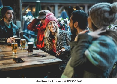 Young People Having Fun Drinking Beer At Pub Restaurant - Soft Focus On Center Girl Face