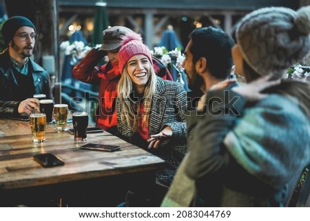 Young people having fun drinking beer at pub restaurant - Soft focus on center girl face