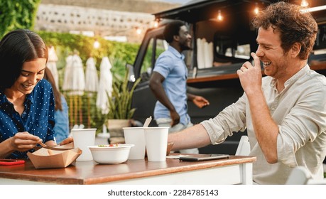 Young people having fun eating at food truck restaurant outdoor - Focus on right man face - Powered by Shutterstock