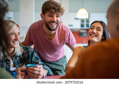 Young People Having Fun In Hostel Living Room, Young Travelers Lifestyle