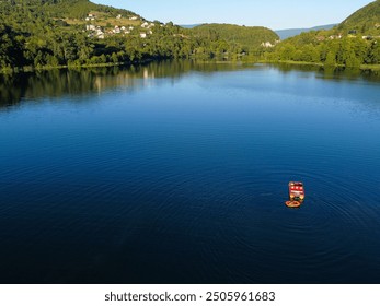 Young people having fun on the boat on the lake, aerial drone view. Tourists enjoy on the water. People on a pedal boat and a rubber boat. Summer holidays.