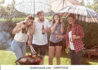 Junge Leute, die sich trotz Regen bei Sonnenuntergang beim Picknick amüsieren