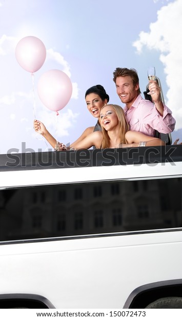 Young people having party in limousine, smiling,
having fun.