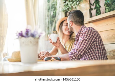 Young People Having Tender Moments Sitting In Cafeteria Backyard Garden - Happy Millennial Couple Drinking Coffee Inside Vintage Bar - Love And Travel Concept - Focus On Man Head 