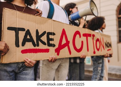 Young People Holding A Banner Sign During An Anti-war Rally In The City. Group Of Multicultural Teenagers Protesting Against War And Violence. Youth Activists Marching The Streets For World Peace.