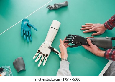 Young People Holding Prototype Of Mechanical Hand In Laboratory