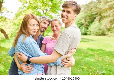 Young people hug each other on a summer meadow for friendship and fellowship - Shutterstock ID 2248015303