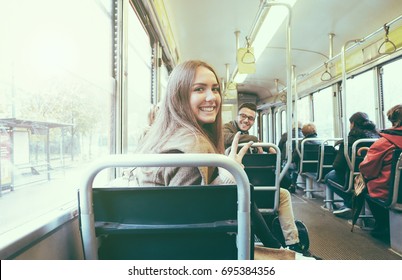 Young people inside old style tram - Happy passengers having fun inside bus - Focus on woman face - Transportation, travel and youth concept - Retro camera filter - Powered by Shutterstock