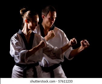 Young people in kimono make martial arts exercise on black - Powered by Shutterstock