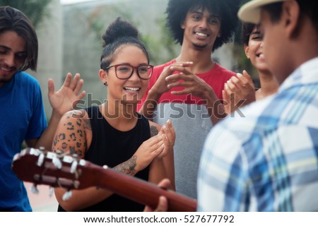 Young people listening to a concert of a guitar player