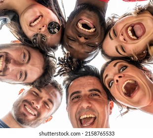 Young People Looking Down At Camera And Laughing, Multiracial Group Of Friends Standing In Circle Smiling At Camera, Diverse Ethnicity Selfie Circle Portrait From Below