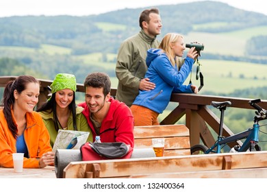 Young people looking through binoculars reading map mountain view holiday - Powered by Shutterstock