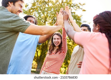 Young people make high five as friends or as a start-up team in a team building workshop - Shutterstock ID 2103786830