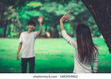 Young People, Man And Woman Greeting Or Saying Goodbye By Waving Hands In The Park.