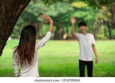 Young People, Man And Woman Greeting Or Saying Goodbye By Waving Hands In The Park.