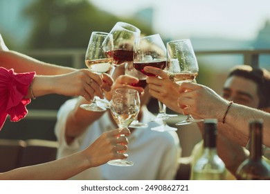 Young people, men and women, friends gather for toast, their drinks sparkling in sunlight and smiles brightening scene. Concept of party, Friday mood, celebration, summer holidays, relax. - Powered by Shutterstock