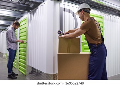 Young people packing boxes with tape and putting them into the boxes while working in storage room - Shutterstock ID 1635522748