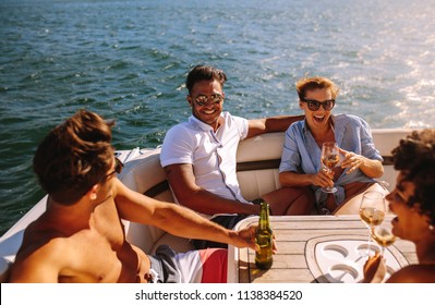 Young people partying on a boat. Men and women laughing and enjoying at yacht party.