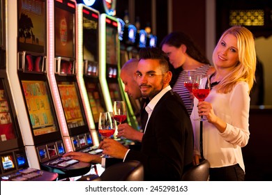 Young People Playing Slot Machines In Casino