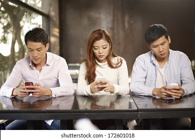 young people playing with smartphones and ignoring each other. - Powered by Shutterstock