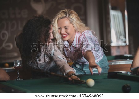 Young people playing snooker at bar