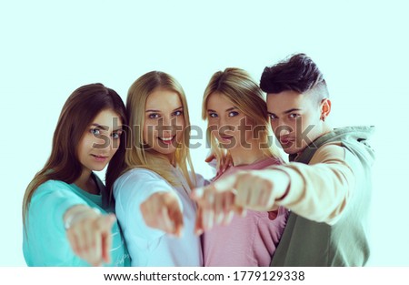 Young people pointing at you standing together