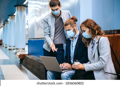 Young People In Protective Masks Using A Laptop On The Subway Platform .