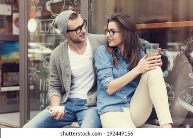 Young people relaxing with cup of coffee outside the cafe - Powered by Shutterstock