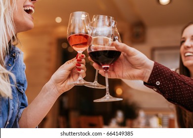 Young People In A Restaurant Cheering With Glasses Of Wine