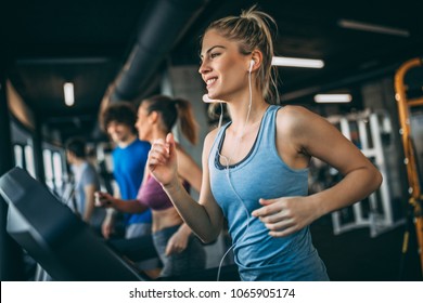 Young people running on a treadmill in health club. - Shutterstock ID 1065905174
