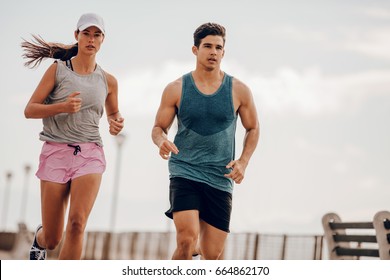 Young People Running Outdoors. Couple Of Runners On Morning Run.