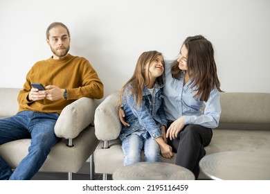 Young people sitting in the lobby of the clinic, waiting for an appointment. Caucasian man and young woman with her daughter - Shutterstock ID 2195116459