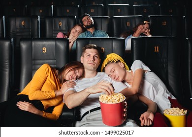 Young People Sleeping During Boring Movie In Cinema, Onlu A Blonde Guy Eating Popcorn And Watching Movie.close Up Photo. Bad Film