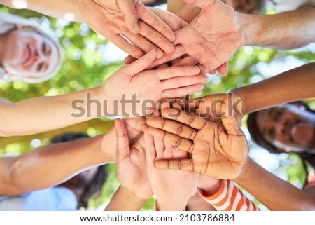 Young people stack many hands as a symbol of team building and network synergy