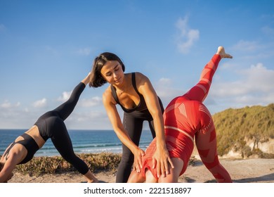 Young People Standing On Mats And Performing Asana With Support Of Yoga Instructor