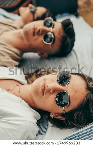 Similar – Women friends with sunglasses looking each other lying